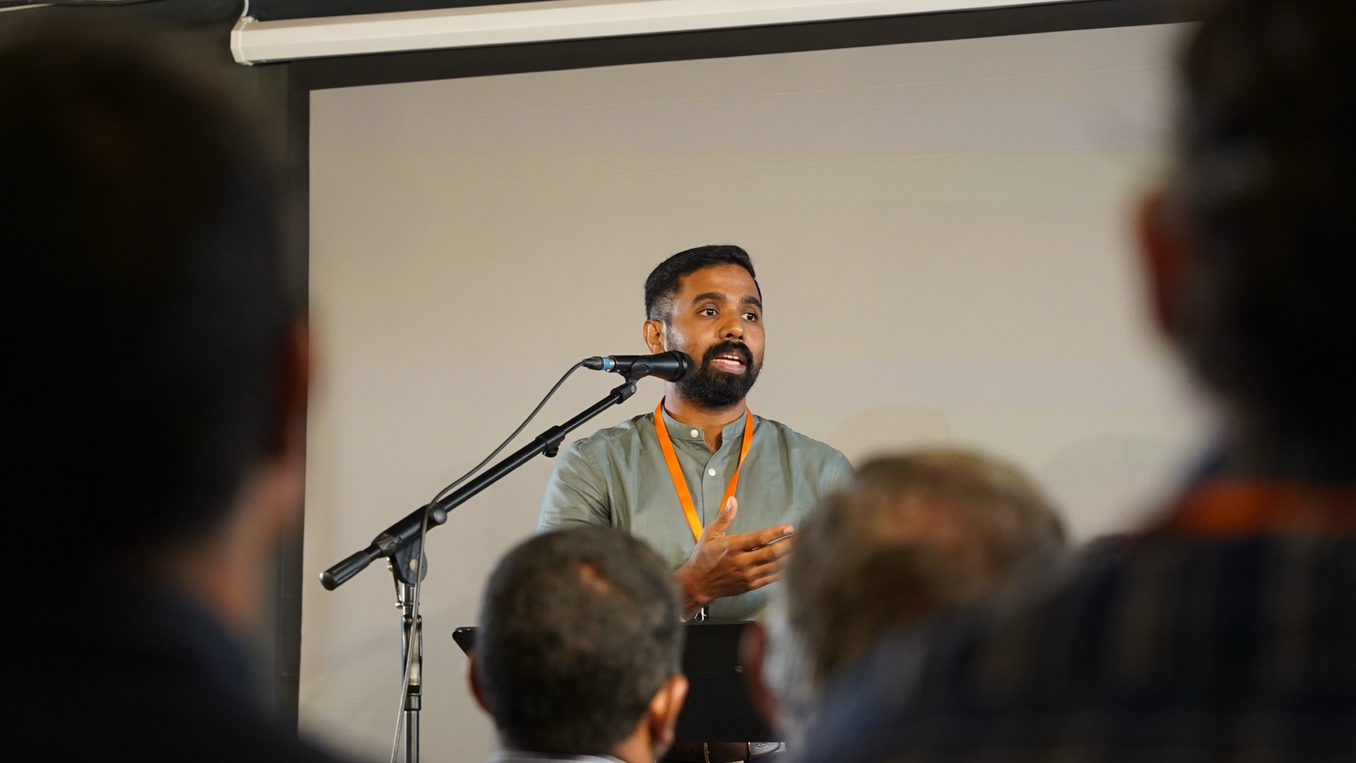 A speaker addressing the audience at a Joy Corp business conference