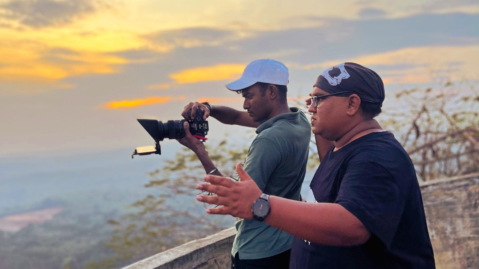 Alin operating a camera with a creative collaborator at sunset